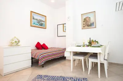 a white dining room with a table and a bed at Casa da Silvia in Palermo