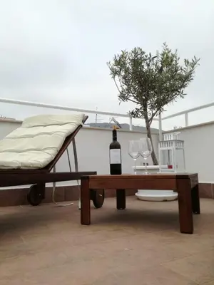 a bottle of wine and a table on a roof at Alto Giardino Rooms in Terrasini
