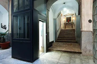 a hallway of a building with a staircase and a door at Maqueda331 in Palermo