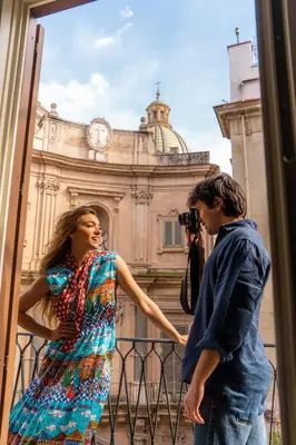 a man taking a picture of a woman in front of a building at InCanto in Palermo