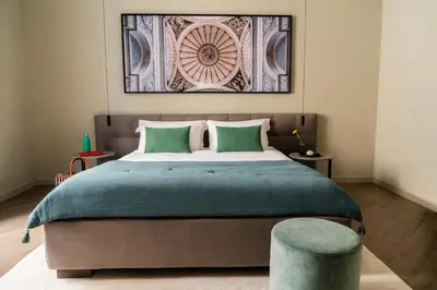 a bedroom with a large bed with a green blanket at InCanto in Palermo