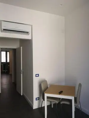 a table and chairs in a room with a heater at LOFT 99 in Palermo