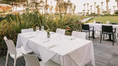 a table with white table cloths and chairs at a restaurant at Mangia's Himera Resort in Campofelice di Roccella