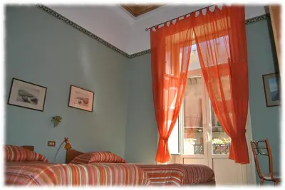a bedroom with an orange curtain and a window at Bed and Breakfast D'Angelo in Palermo