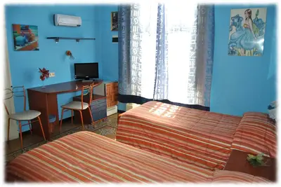 a bedroom with a bed and a desk with a computer at Bed and Breakfast D'Angelo in Palermo