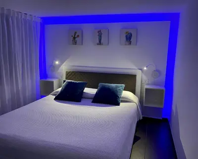 a bedroom with a bed with blue lights on it at La Caletta Casa Vacanze, PRIVATE POOL in Terrasini