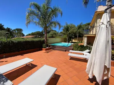 a patio with a pool and a umbrella and a swimming pool at La Caletta Casa Vacanze, PRIVATE POOL in Terrasini