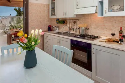 a kitchen with a vase of flowers on a table at Carlottas Home in San Vito lo Capo