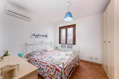 a white bedroom with a bed and a desk at Carlottas Home in San Vito lo Capo