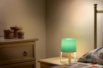 a bedroom with a green lamp next to a bed at Carlottas Home in San Vito lo Capo
