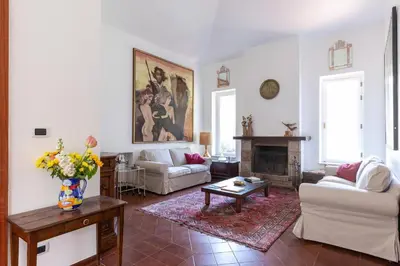 a living room with white furniture and a fireplace at Il Giardino di Michela by DomuSicily in Mondello