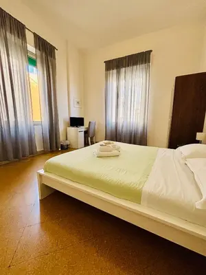 a bedroom with a large white bed with windows at Mamamia #Politeama in Palermo