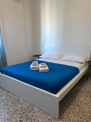 a bed with blue sheets and two towels on it at Mamamia #Politeama in Palermo