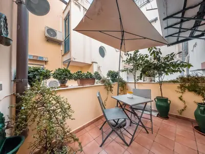 a table and chairs on a balcony with plants at Casa Ruggiero in Palermo