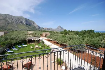a balcony with a view of a garden with chairs at Trigrana Vacanze Hotel in Castelluzzo