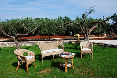 a group of chairs and a table in the grass at Trigrana Vacanze Hotel in Castelluzzo