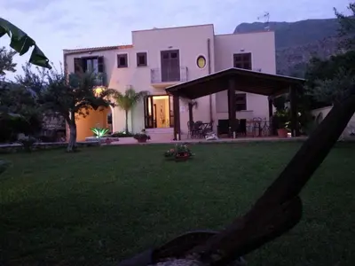 a large white house with a yard with a house at Trigrana Vacanze Hotel in Castelluzzo