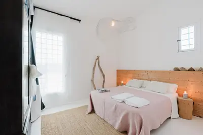 a bedroom with a bed and a chair and a mirror at casa zabbara in Balestrate
