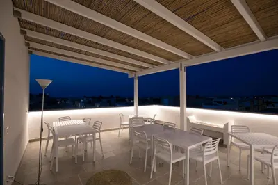 a balcony with tables and chairs and a view of the city at Cocciu d'amuri in San Vito lo Capo