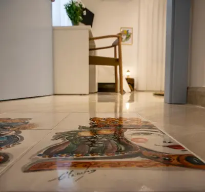 a rug on the floor in a room with a chair at Cocciu d'amuri in San Vito lo Capo