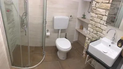 a bathroom with a shower and a toilet and a sink at Villa Araucaria in Partinico