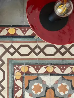 a red bowl on a floor with a tile floor at B&B Palazzo Corselli in Bagheria