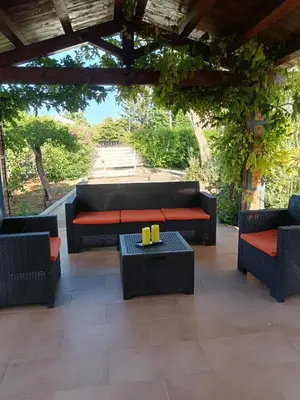 a patio with couches and a table and chairs at Villa Serrano in Palermo