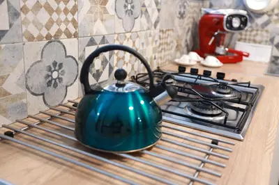 a blue tea kettle sitting on top of a stove at La Casetta delle Scienze in Palermo