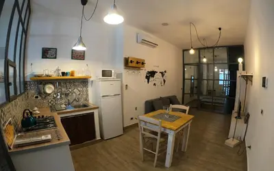 a kitchen with a counter and a table in a room at La Casetta delle Scienze in Palermo