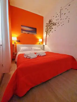 a bedroom with a red bed with towels on it at A un passo dal centro in Palermo