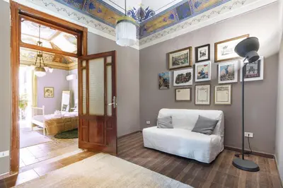 a living room with a door and a white chair at SUITE S.LUCIA in Corleone