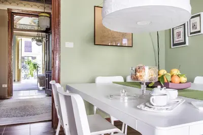 a dining room with a white table and white chairs at SUITE S.LUCIA in Corleone
