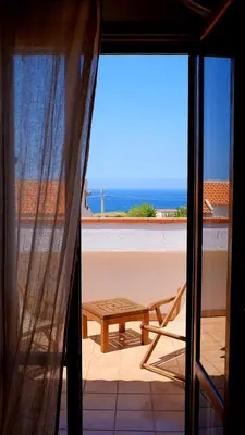 a view of a table and a bench from a window at Casa Mandarino in Macari