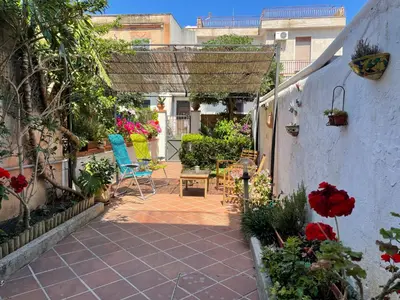 a patio with chairs and flowers in a courtyard at Da Sophie in Mondello
