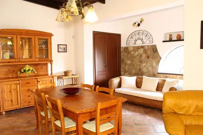 a living room with a wooden table and a couch at Villa Porto Rais in Carini