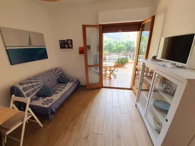 a living room with a couch and a sliding glass door at La Locanda del Cedro in Palermo