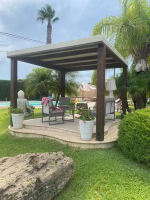 a wooden gazebo with a table and chairs at Villa Grisì in Partinico