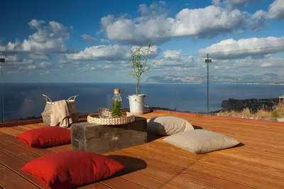 a deck with pillows and a view of the ocean at Casa Saleiman in Castellammare del Golfo