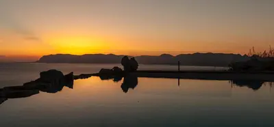 a sunset over the water with mountains in the background at Casa Saleiman in Castellammare del Golfo