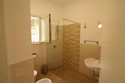 a bathroom with a glass shower and a sink at Casa Saline in Mondello
