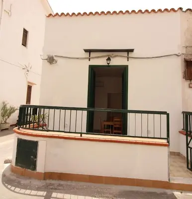 a balcony of a white building with a green door at Casa Saline in Mondello
