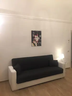 a couch in a living room with a picture on the wall at Casa Vacanza La Pergola in Terrasini