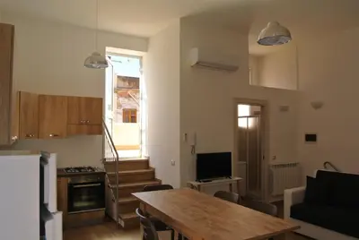 a kitchen and living room with a table and a television at Casa Vacanza La Pergola in Terrasini
