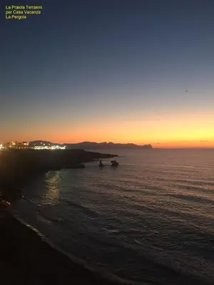 a sunset over the ocean with two boats in the water at Casa Vacanza La Pergola in Terrasini
