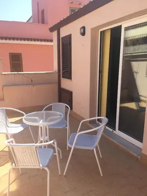 a patio with a table and chairs on a balcony at Casa Vacanze La Pergola@ in Terrasini