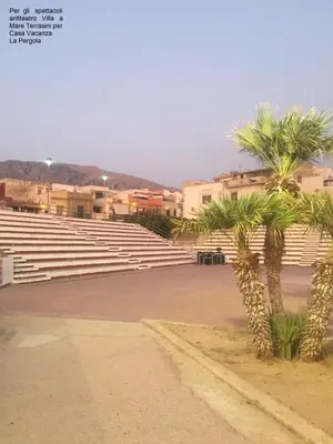 a large amphitheater with palm trees and buildings at Casa Vacanze La Pergola@ in Terrasini