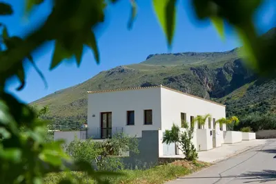 a white house with a mountain in the background at Al Cantuccio in Castelluzzo