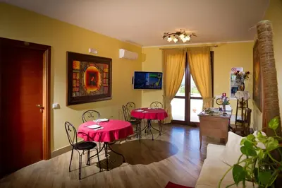 a living room with two red tables and chairs at Al Cantuccio in Castelluzzo