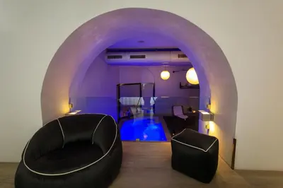 a living room with a chair and a swimming pool at Quintocanto Hotel & Spa in Palermo