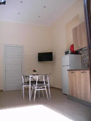 a small kitchen with a table and a refrigerator at La Casetta del Viale 13 in Palermo